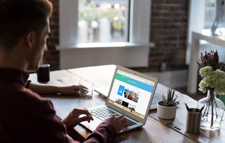 male using twitter on laptop
