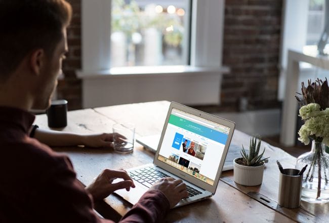 male using twitter on laptop